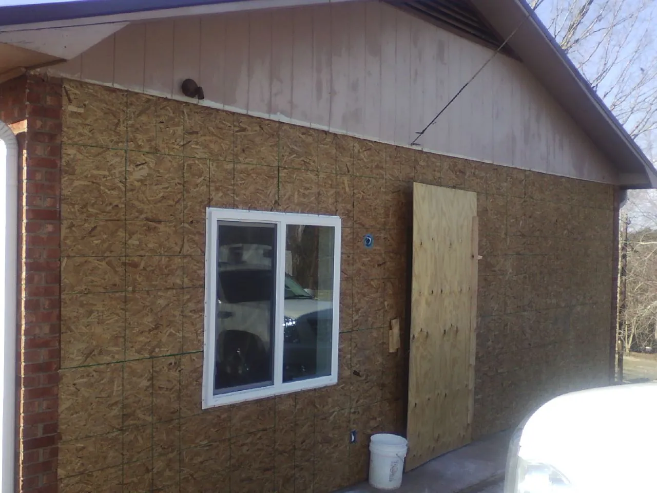 OSB sheathing on a garage addition wall before siding in Raymond