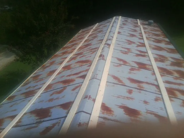 Rusted metal roof panels with new wood purlins before replacement — Storm Damage Roof Repair in Raymond by Roofing Brothers