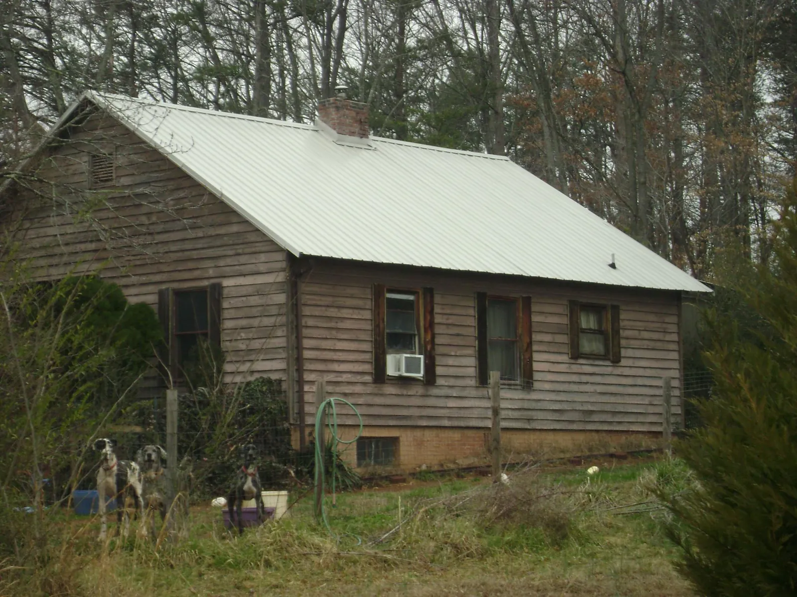 White metal roof on an old wood sided farmhouse, from a Metal Roof Installation job in Raymond